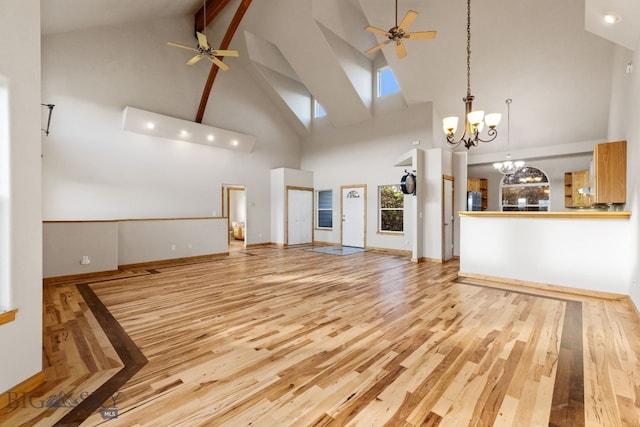 74 W Clara Ct, Bozeman, MT 59718 - unfurnished living room featuring a ceiling fan, high vaulted ceiling, wood finished floors, a chandelier, and beam ceiling