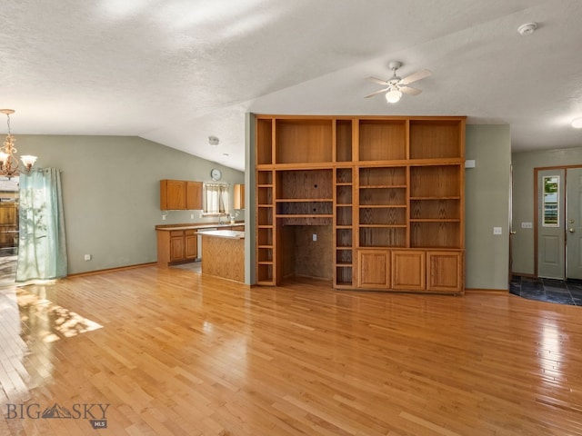 3455 W Cascade, Bozeman, MT 59718 - unfurnished living room with light wood-style floors, vaulted ceiling, a ceiling fan, a chandelier, and a textured ceiling