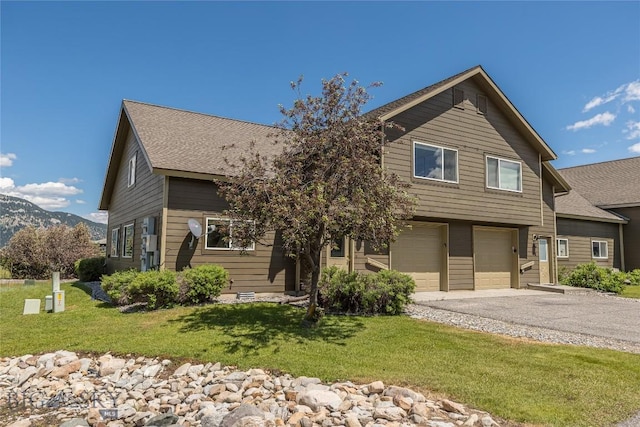 344 Candlelight Meadow Dr, Big Sky, MT 59716 - view of front of property featuring an attached garage, asphalt driveway, a front yard, a mountain view, and roof with shingles