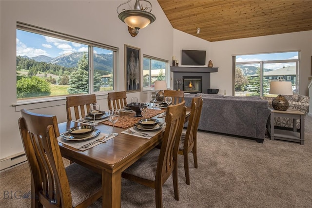 344 Candlelight Meadow Dr, Big Sky, MT 59716 - dining space with vaulted ceiling, light colored carpet, healthy amount of natural light, a glass covered fireplace, and a mountain view