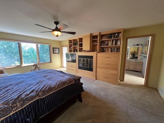 3 Gallatin Unit B, Bozeman, MT 59718 - carpeted bedroom featuring a glass covered fireplace, ensuite bath, and a ceiling fan