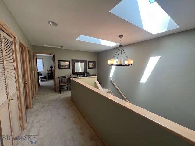 3 Gallatin Unit B, Bozeman, MT 59718 - hall featuring a skylight, light colored carpet, an upstairs landing, a chandelier, and recessed lighting