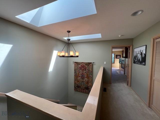 3 Gallatin Unit B, Bozeman, MT 59718 - hallway featuring a skylight, an upstairs landing, carpet floors, and a chandelier