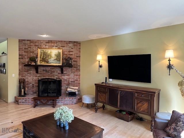 3 Gallatin Unit B, Bozeman, MT 59718 - living room featuring light wood-style flooring and a brick fireplace