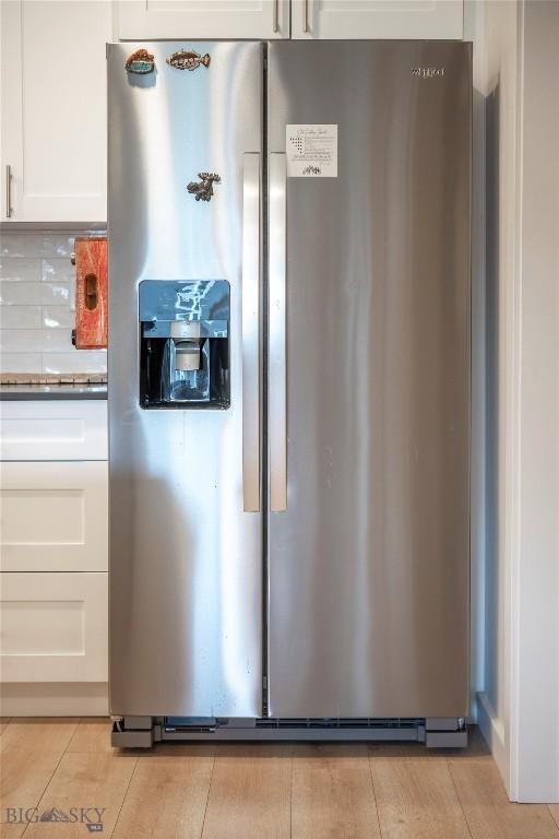 2221D Willow Dr Unit 128, Livingston, MT 59047 - kitchen view of stainless steel refrigerator with ice dispenser, white cabinets, dark countertops, and decorative backsplash