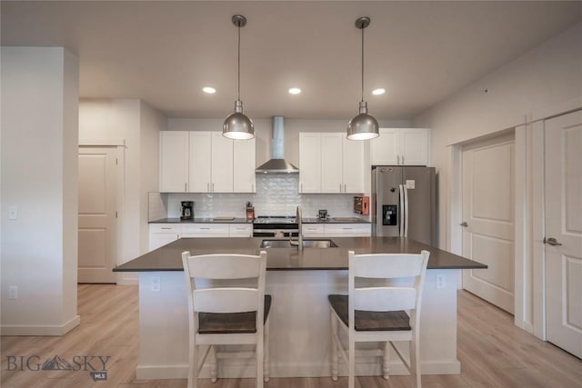 2221D Willow Dr Unit 128, Livingston, MT 59047 - kitchen with stainless steel appliances, wall chimney exhaust hood, dark countertops, light wood-style floors, and recessed lighting