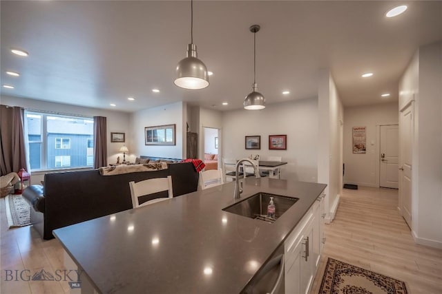 2221D Willow Dr Unit 128, Livingston, MT 59047 - kitchen with open floor plan, white cabinetry, recessed lighting, a center island with sink, and decorative light fixtures