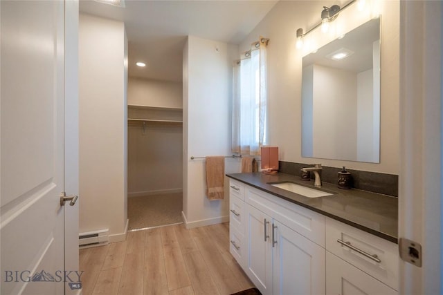2221D Willow Dr Unit 128, Livingston, MT 59047 - bathroom with vanity, a baseboard heating unit, wood finished floors, a spacious closet, and recessed lighting