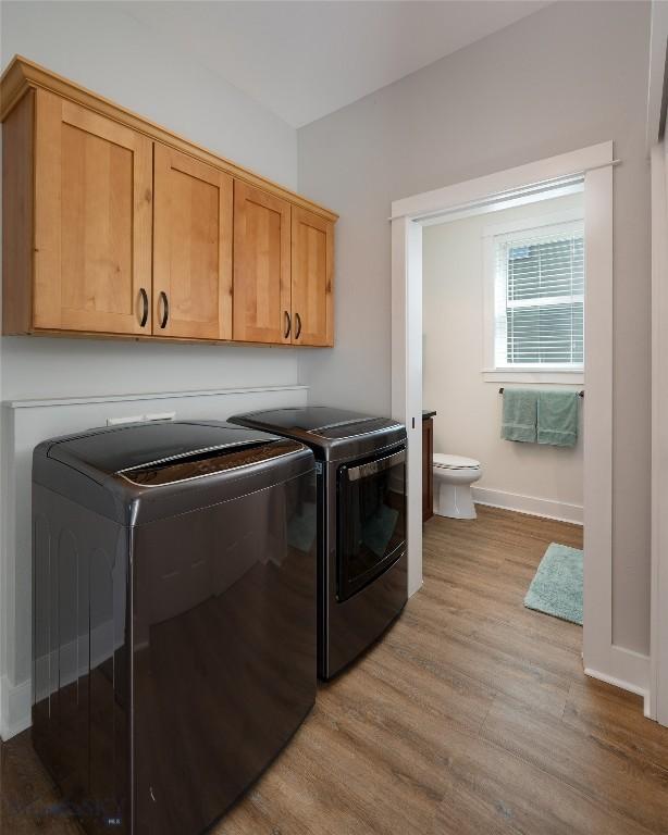 3090 Meah Ln, Bozeman, MT 59718 - washroom with washing machine and dryer, light wood-style flooring, and cabinet space