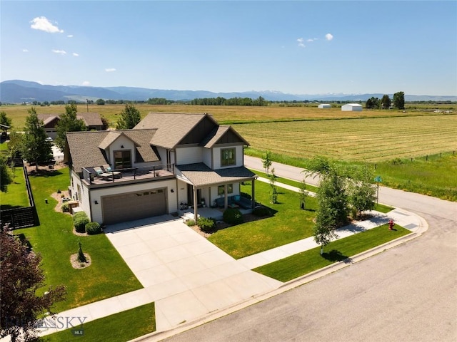3090 Meah Ln, Bozeman, MT 59718 - view of front facade featuring a garage, concrete driveway, a porch, a front yard, and a view of countryside