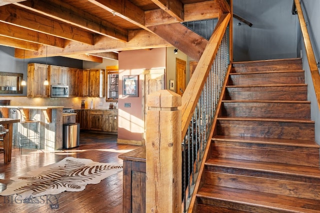 58 Upper Moose Hill Rd, Big Sky, MT 59716 - staircase with hardwood / wood-style flooring and beam ceiling