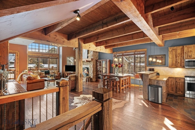 58 Upper Moose Hill Rd, Big Sky, MT 59716 - living room featuring dark wood-type flooring, healthy amount of natural light, a wood ceiling with exposed beams, and a fireplace