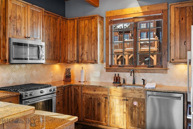 58 Upper Moose Hill Rd, Big Sky, MT 59716 - kitchen with stainless steel appliances, decorative backsplash, brown cabinetry, and light stone countertops