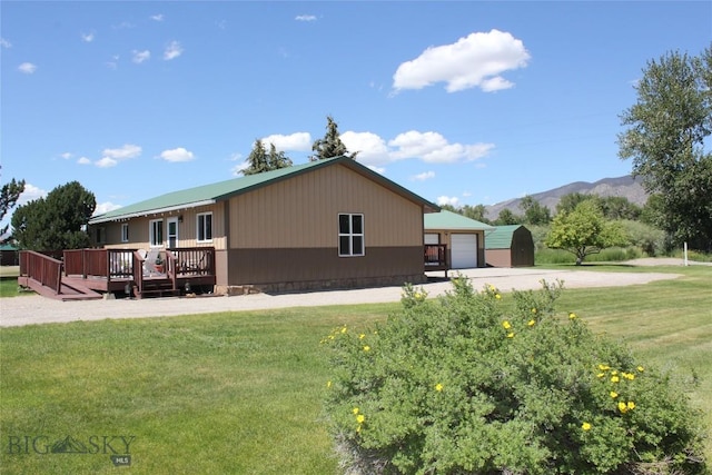 19970 Mt Highway 91 N, Glen, MT 59732 - view of side of home featuring a garage, a lawn, an outdoor structure, and a deck with mountain view