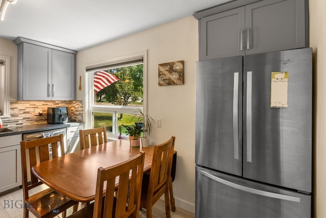 531 N Main St, Livingston, MT 59047 - kitchen featuring freestanding refrigerator, gray cabinets, backsplash, and dark countertops