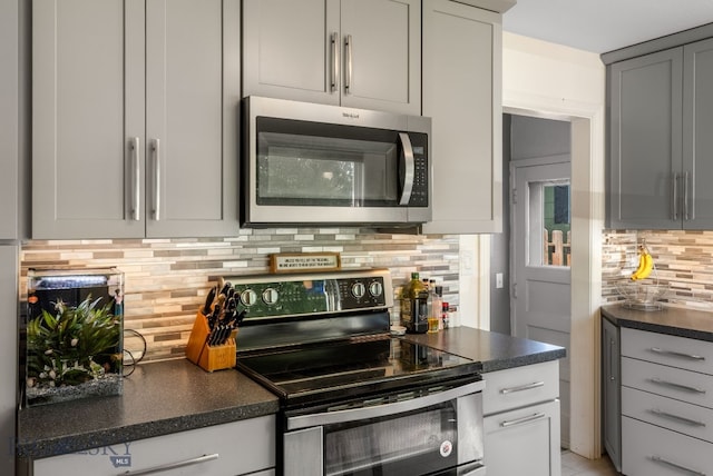 531 N Main St, Livingston, MT 59047 - kitchen with stainless steel appliances, dark countertops, backsplash, and gray cabinets