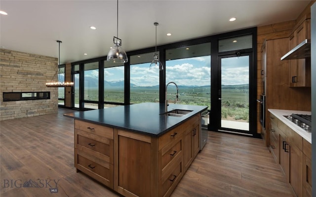 28 Elk Meadows Ranch Rd, Cameron, MT 59720 - kitchen featuring stainless steel gas cooktop, floor to ceiling windows, dark wood-style floors, dark countertops, and a kitchen island with sink