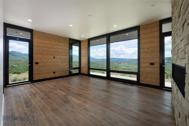 28 Elk Meadows Ranch Rd, Cameron, MT 59720 - spare room with expansive windows, dark wood finished floors, wood walls, a mountain view, and a stone fireplace