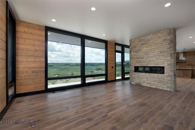 28 Elk Meadows Ranch Rd, Cameron, MT 59720 - unfurnished living room with healthy amount of natural light, expansive windows, wood finished floors, a stone fireplace, and recessed lighting