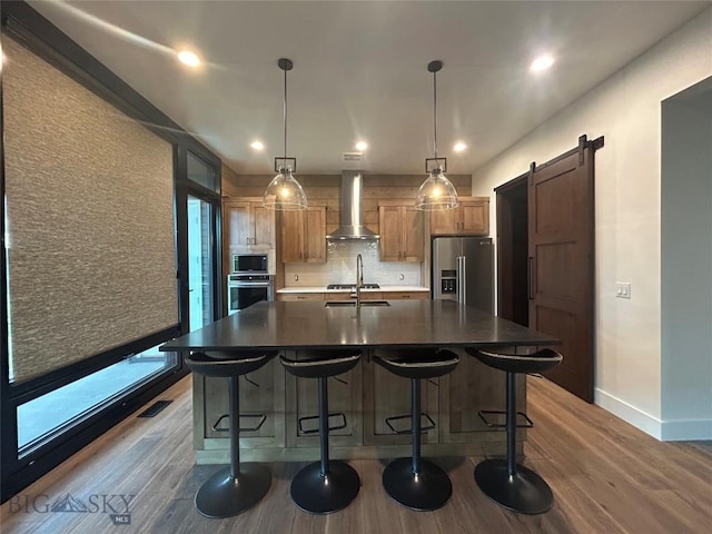 28 Elk Meadows Ranch Rd, Cameron, MT 59720 - kitchen with appliances with stainless steel finishes, wall chimney exhaust hood, dark wood-type flooring, a large island with sink, and recessed lighting
