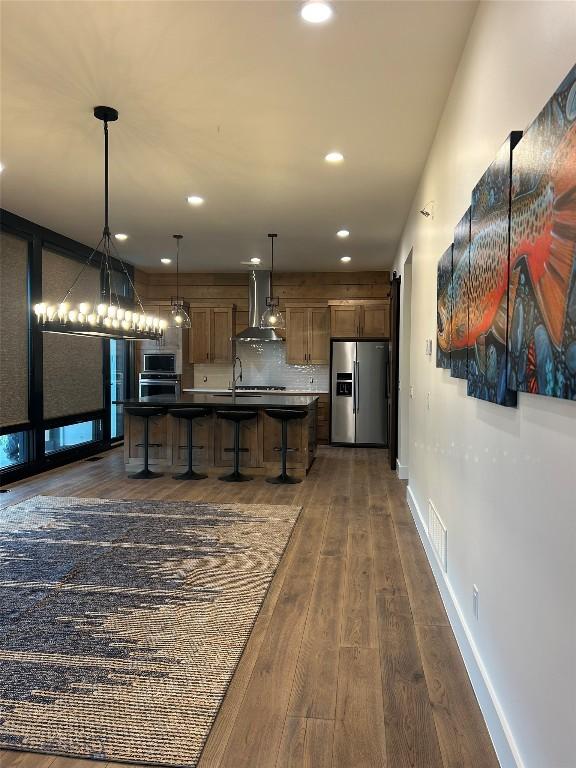 28 Elk Meadows Ranch Rd, Cameron, MT 59720 - kitchen featuring stainless steel appliances, wall chimney exhaust hood, dark wood-style floors, recessed lighting, and a breakfast bar