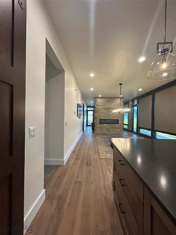 28 Elk Meadows Ranch Rd, Cameron, MT 59720 - kitchen with a stone fireplace, dark countertops, dark wood-style floors, recessed lighting, and open floor plan