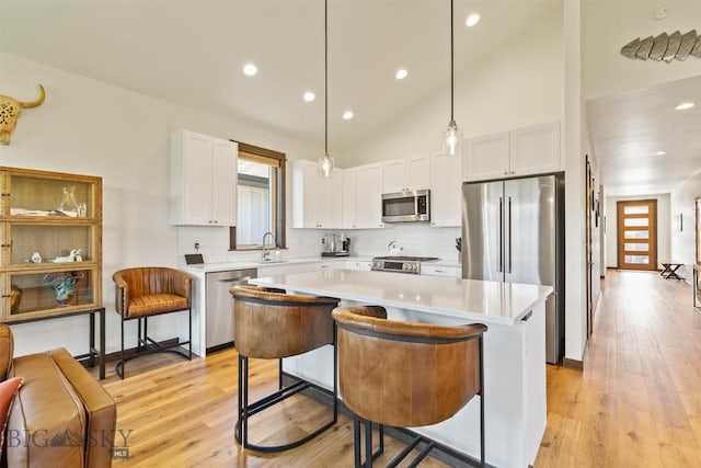 205 Albrey Trl Unit B, Bozeman, MT 59718 - kitchen with stainless steel appliances, decorative backsplash, a kitchen island, white cabinetry, and light countertops