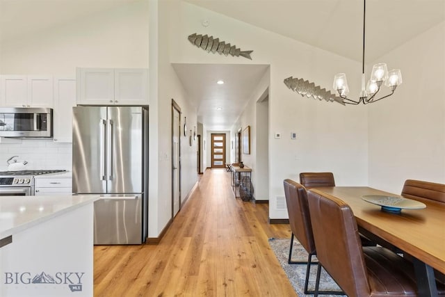 205 Albrey Trl Unit B, Bozeman, MT 59718 - dining space with light wood finished floors, vaulted ceiling, and a chandelier