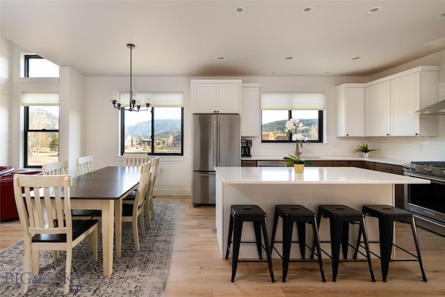 87 Upper Whitefish Dr, Big Sky, MT 59716 - kitchen featuring appliances with stainless steel finishes, a kitchen island, a kitchen breakfast bar, plenty of natural light, and recessed lighting