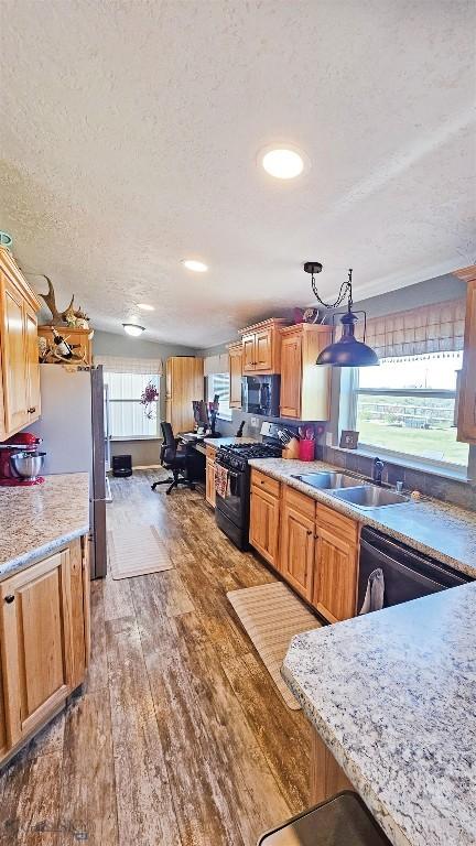 950 N Harrison St, Lima, MT 59739 - kitchen with black appliances, a textured ceiling, wood finished floors, light countertops, and recessed lighting