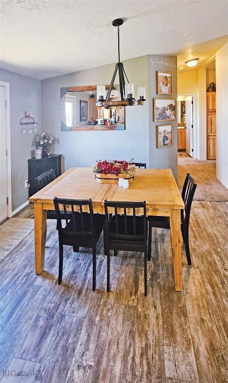 950 N Harrison St, Lima, MT 59739 - dining area with wood finished floors, a chandelier, and a textured ceiling