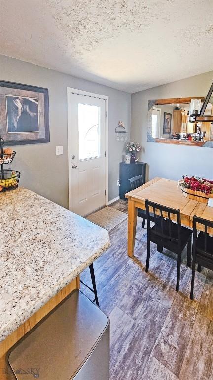 950 N Harrison St, Lima, MT 59739 - dining space featuring a textured ceiling and wood finished floors