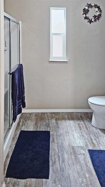950 N Harrison St, Lima, MT 59739 - bathroom featuring wood finished floors and a stall shower