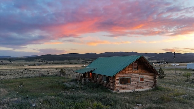 7223 Birdseye Rd, Helena, MT 59602 - property exterior at dusk with log exterior, a mountain view, and a metal roof