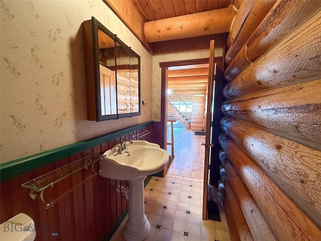 7223 Birdseye Rd, Helena, MT 59602 - half bath featuring log walls, a wainscoted wall, and wood ceiling