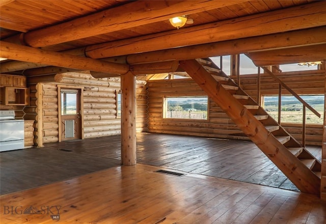 7223 Birdseye Rd, Helena, MT 59602 - unfurnished living room with hardwood / wood-style flooring, stairs, log walls, and a wooden ceiling with exposed beams