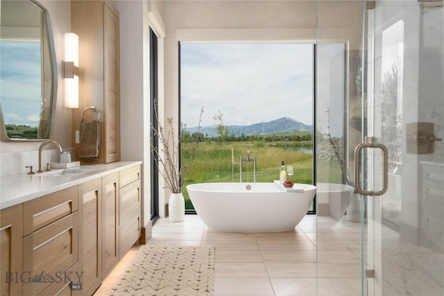 240 Horsetail Rd, Bozeman, MT 59715 - full bathroom featuring vanity, a freestanding bath, a mountain view, tile patterned floors, and a shower stall