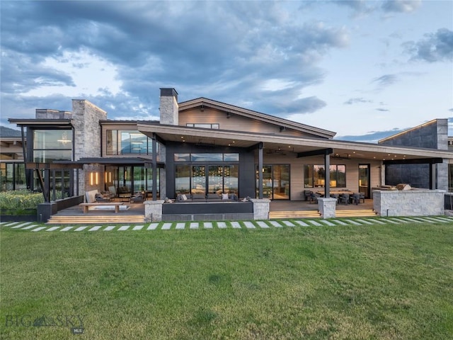 240 Horsetail Rd, Bozeman, MT 59715 - rear view of house with a patio, a lawn, a chimney, and outdoor lounge area