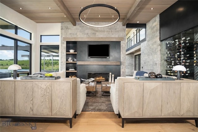 240 Horsetail Rd, Bozeman, MT 59715 - living area with a towering ceiling, a wooden ceiling with exposed beams, wood finished floors, a large fireplace, and healthy amount of natural light