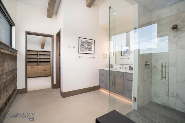 240 Horsetail Rd, Bozeman, MT 59715 - bathroom featuring a marble finish shower, beamed ceiling, vanity, a spacious closet, and tile patterned floors