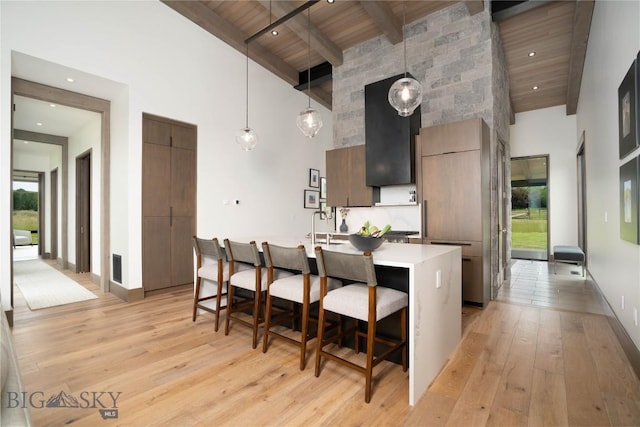 240 Horsetail Rd, Bozeman, MT 59715 - kitchen featuring high vaulted ceiling, modern cabinets, a wooden ceiling with exposed beams, light wood finished floors, and light countertops