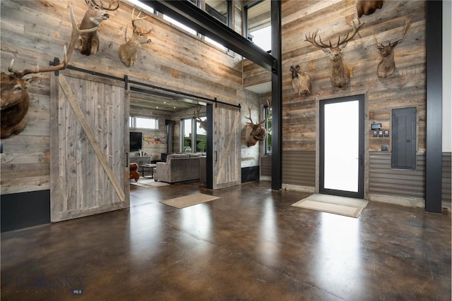 240 Horsetail Rd, Bozeman, MT 59715 - foyer entrance featuring a barn door, a high ceiling, concrete flooring, and wood walls