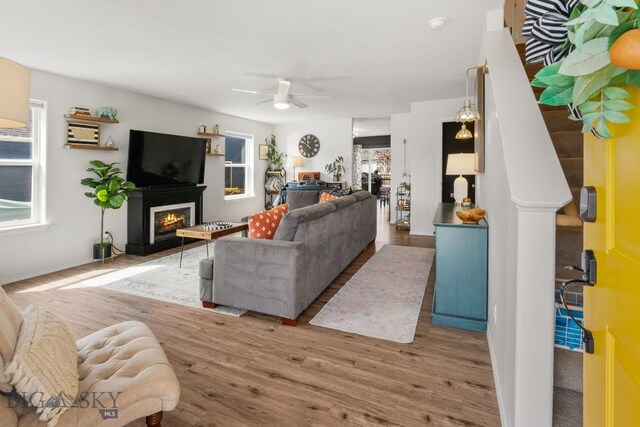 119 Meadow Brook Ln, Belgrade, MT 59714 - living area with wood finished floors, a glass covered fireplace, and ceiling fan
