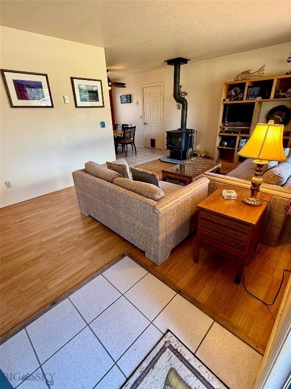 1364 Mcclellan Rd, West Yellowstone, MT 59758 - living room featuring a wood stove and tile patterned floors