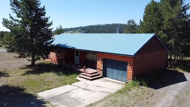 1364 Mcclellan Rd, West Yellowstone, MT 59758 - view of front of property featuring a garage, driveway, and a metal roof