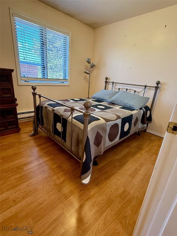 1364 Mcclellan Rd, West Yellowstone, MT 59758 - bedroom featuring light wood-style flooring and a baseboard heating unit