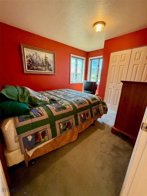 1364 Mcclellan Rd, West Yellowstone, MT 59758 - carpeted bedroom with a textured ceiling and a closet