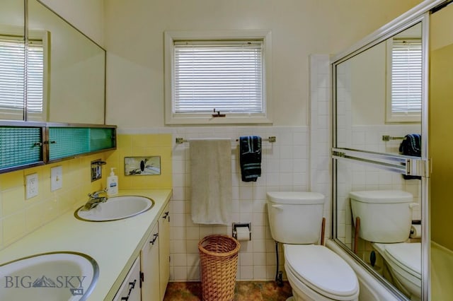511 W Babcock, Bozeman, MT 59715 - bathroom with tile walls, double vanity, wainscoting, and bath / shower combo with glass door