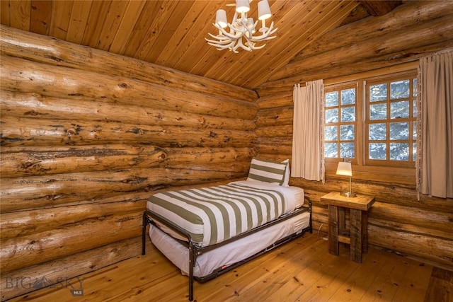49824 Gallatin Rd, Big Sky, MT 59730 - bedroom featuring a chandelier, lofted ceiling, hardwood / wood-style flooring, rustic walls, and wooden ceiling