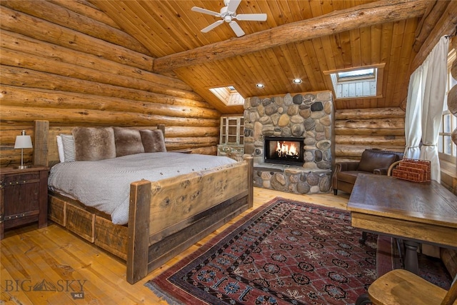 49824 Gallatin Rd, Big Sky, MT 59730 - bedroom with wood ceiling, hardwood / wood-style floors, a skylight, a stone fireplace, and log walls